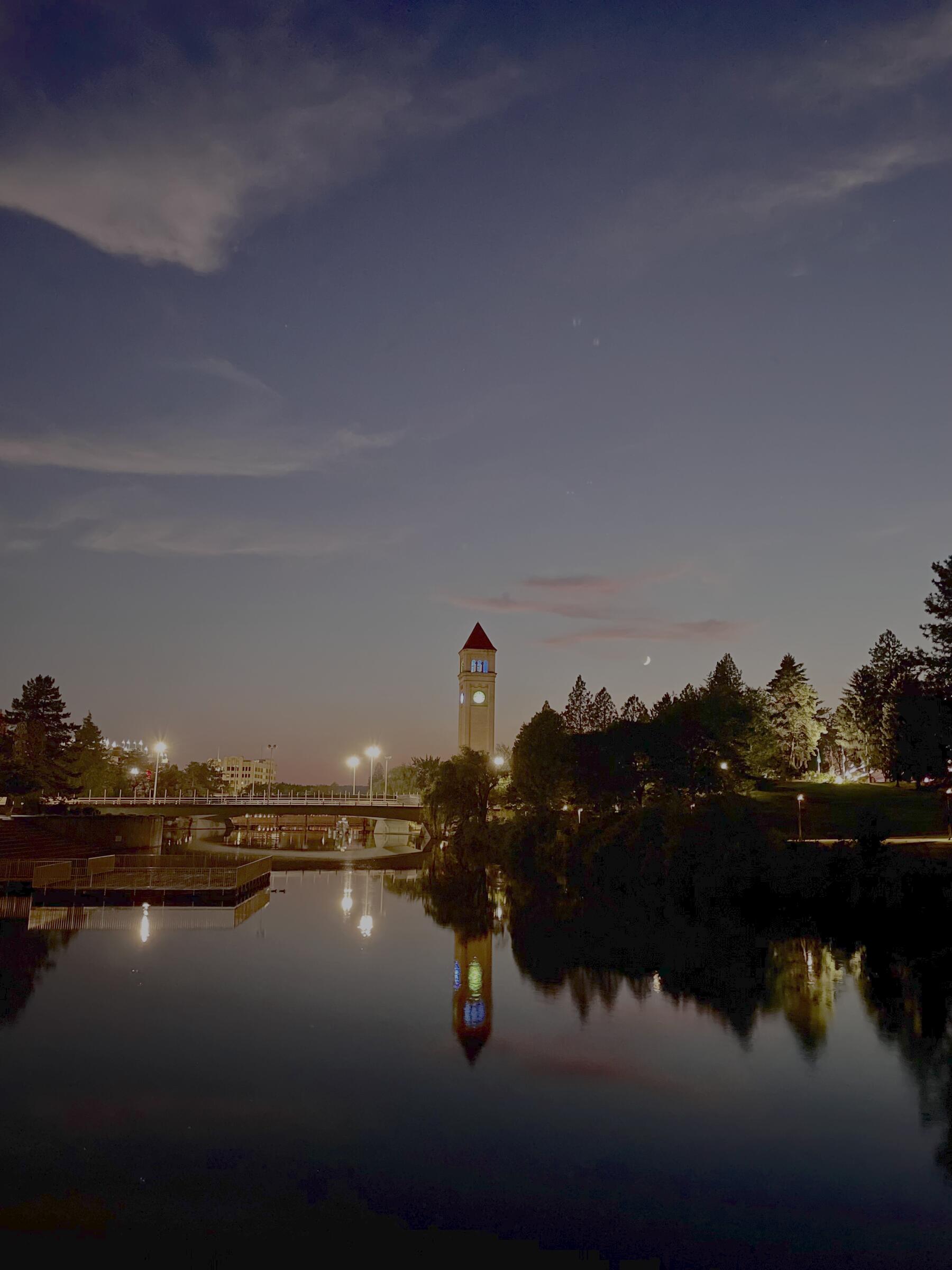 Spokane clock tower at night with river reflection